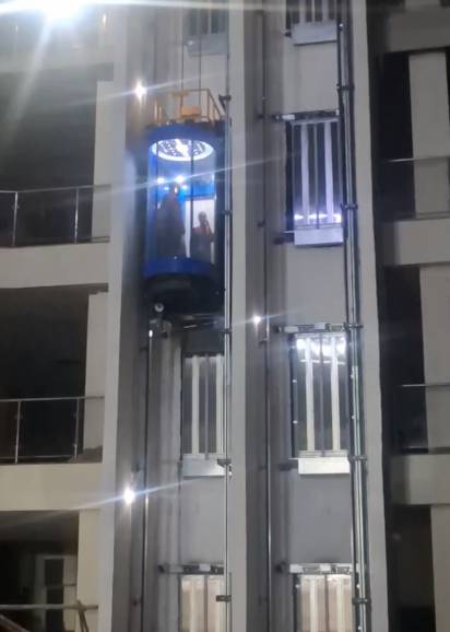 Panoramic elevator installed on building exterior at night